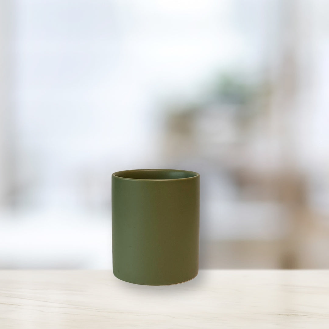 Empty sage green candle vessel on white background, representing selecting a vessel for candle making.