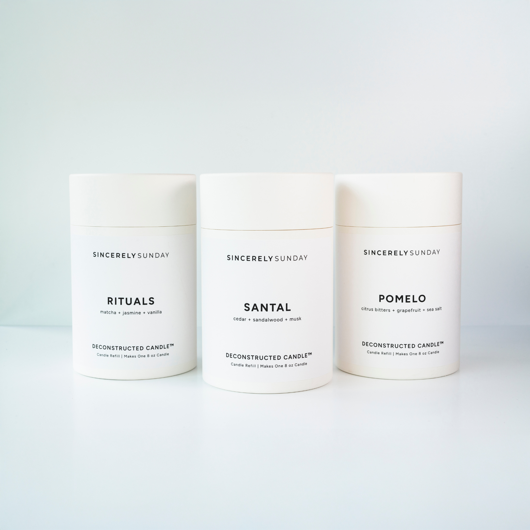 Three 'Sincerely Sunday' candles with different scents on a white background