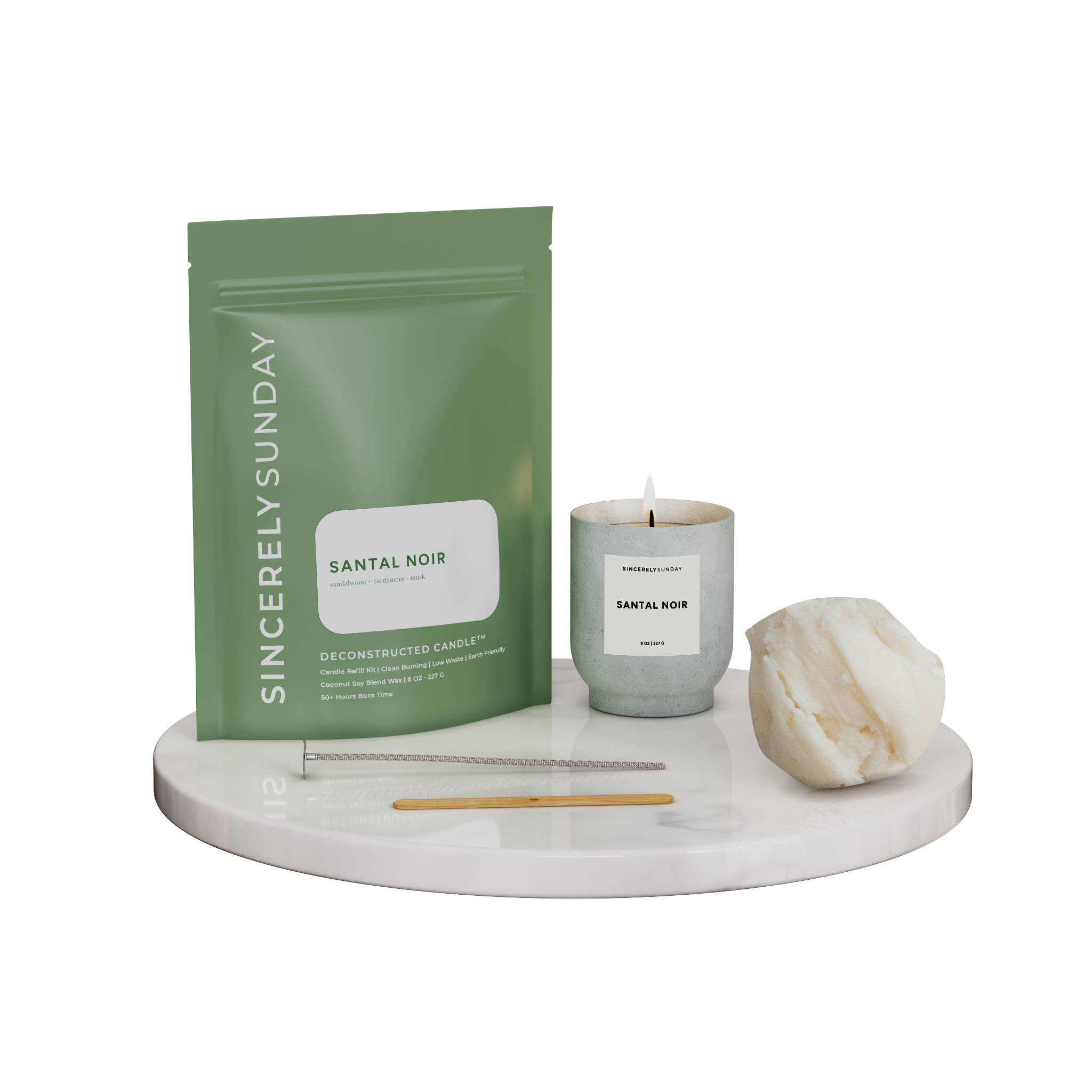 Santal Noir Deconstructed Candle™ kit with cotton wick, wooden wick holder, ball of wax, and pouch on a marble platform, showcasing all included items. Also shown is a candle in a light gray ceramic vessel to indicate what the candle would look like once it is made.