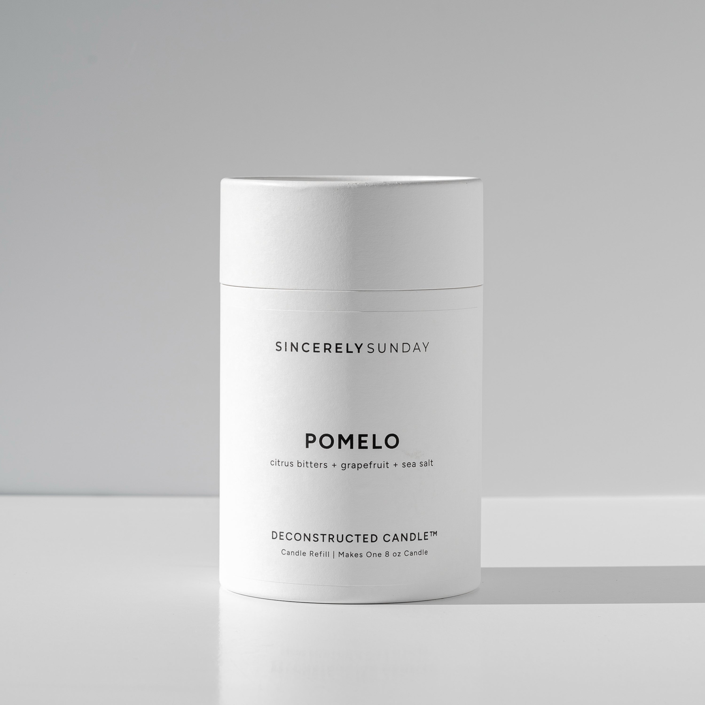 White cylindrical paper tube labeled 'Pomelo' by Sincerely Sunday on a white background