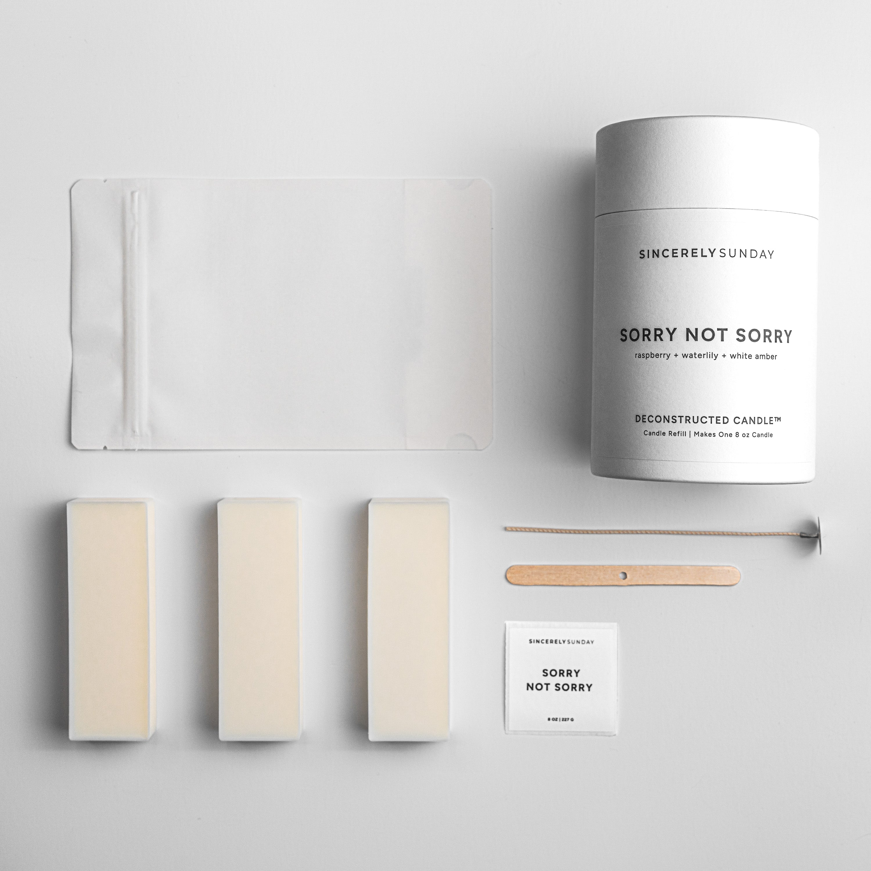 Sincerely Sunday candle with wax bars, a white pouch, wick, and wick holder on a light gray background